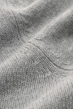 Nahaufnahme des mittelgroben Strickbilds vom Allude Troyer grau meliert, Mix aus Schurwolle und Cashmere, weicher Griff, Regular Fit, Stehkragen mit Vier-Knopf-Leiste und komfortable Rippbündchen.