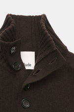 Nahaufnahme aus schräger Perspektive des Allude Troyer dunkelbraun mit Stehkragen, Vier-Knopf-Leiste, mittelgroßem Strickbild, weichem Griff, Rippbündchen, Regular Fit, Mix aus Schurwolle und Cashmere.