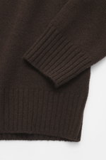 Nahaufnahme des Allude Troyer dunkelbraun, mittleres Strickbild, weicher Griff, Regular Fit, Rippbündchen, von oben fotografiert.