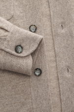 Nahaufnahme des Allude Strickhemds taupe meliert aus schräger Draufsicht mit feinem Strickbild, glatter Knopfleiste, Umlegekragen, aufgesetzten Brusttaschen, komfortablen Rippbündchen, Regular Fit und weichem Griff aus Schurwolle und Cashmere.