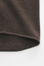 Nahaufnahme des Allude Strickhemds dunkelbraun von unten, zeigt feines Strickbild, weichen Griff, Rippbündchen, Regular Fit, Umlegekragen, glatte Knopfleiste, Brusttaschen, Mix aus Schurwolle und Cashmere.