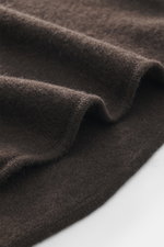 Nahaufnahme des weichen, dunkelbraunen Allude Strickhemds aus Schurwolle und Cashmere, detailreiches Strickbild, Regular Fit, Umlegekragen, Brusttaschen, glatte Knopfleiste, Rippbündchen sichtbar.