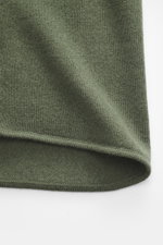 Nahaufnahme des Allude Strickhemds dunkelgrün aus Schurwolle und Cashmere, weicher Griff, feines Strickbild, Regular Fit, glatte Knopfleiste, Umlegekragen, Brusttaschen, Rippbündchen, Detailansicht der Textur.