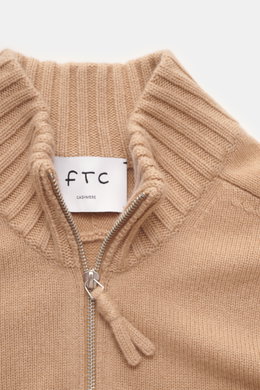Nahaufnahme des FTC Cashmere Troyer camel von oben, weicher Griff, feines Strickbild, Troyer-Kragen mit Reißverschluss, Regular Fit.
