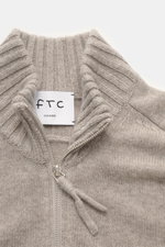 Nahaufnahme aus leichter Draufsicht des FTC Cashmere Troyer sand meliert mit Troyer-Kragen, Reißverschluss, feinem Strickbild und weichem Griff.