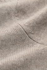 Nahaufnahme des feinen Strickbilds und weichen Griffs des FTC Cashmere Troyer sand meliert, fotografiert in Makroperspektive.