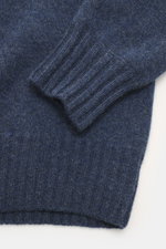 Nahaufnahme des FTC Cashmere Troyer graublau meliert, Detailansicht von weichem, feinem Strick und Rippbündchen, perspektivisch fotografiert.