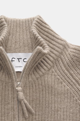 Nahaufnahme des FTC Cashmere Troyer beige meliert von oben, zeigt Troyer-Kragen mit Reißverschluss, mittelgrobes Strickbild, weichen Griff, Regular Fit, Rippbündchen für luxuriösen Komfort.