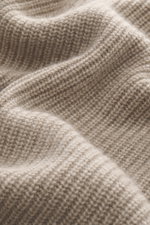 Nahaufnahme des weichen, mittelgroben Strickbildes des FTC Cashmere Troyer beige meliert aus reiner Cashmere-Faser.