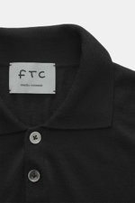 Nahaufnahme von FTC Strickpolo schwarz mit klassischem Polokragen, Perlmuttknöpfen, feinem Cashmere-Lyocell-Strick und Slim Fit, von oben fotografiert.