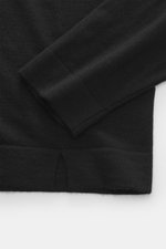 Nahaufnahme des FTC Strickpolo schwarz von oben, zeigt Saum mit kurzen Schlitzen, feines Strickbild, soften Griff, Slim Fit.