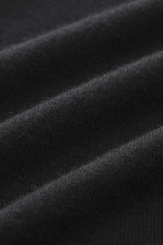 Nahaufnahme des schwarzen FTC Strickpolo slim fit aus Cashmere und Lyocell mit klassischem Polokragen, Perlmuttknöpfen, feinem Strickbild und Saumschlitzen.