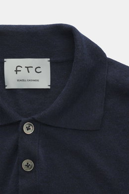 Nahaufnahme des FTC Strickpolo navy aus Cashmere und Lyocell, Slim Fit, klassischer Polokragen, Perlmuttknöpfe, feines Strickbild, von oben fotografiert.