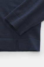 Nahaufnahme des FTC Strickpolo navy, fotografiert von oben auf Ärmel und Saum, Strick aus Cashmere und Lyocell (Seacell), softer Griff, sehr feines Strickbild, Slim Fit, klassischer Polokragen, typische Drei-Knopf-Leiste, Perlmuttknöpfe, doppelt gearbeite