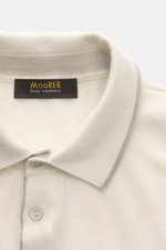 Close-up top view of Moorer Cashmere fine knit polo 'Teramo' cream showing polo collar, button placket with mother-of-pearl buttons, and narrow contrast edges, made of pure baby cashmere with a soft feel and very fine knit pattern, slim fit, and flexible 