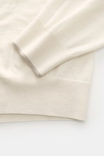 Close-up from above of the sleeve and hem of the Moorer Cashmere fine knit polo 'Teramo' cream, showing fine knit, soft feel, narrow contrast edges, and ribbed cuff. Palpable luxury: The exquisite knit polo 'Teramo' by MOORER is made of pure baby cashmere