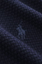 Nahaufnahme des dunkelblauen Slim Fit Polo Ralph Lauren Troyer navy aus reiner Wolle, Strukturstrick mit tonalem Polospieler-Stitching.