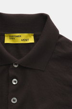 Close-up front view of B.F. Knitwear Merino knit polo dark violet showing classic polo collar, fine knit pattern, buttons, and ribbed cuffs, knit from pure merino wool with a soft feel and regular fit.