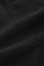 Nahaufnahme des von Braun Merino Feinstrickpolo schwarz aus reiner Merinowolle, Slim Fit, schmaler Polokragen, glatte Drei-Knopf-Leiste, flexible Rippbündchen, weicher Griff, feines Strickbild, fotografiert aus schräger Perspektive.