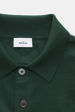 Nahaufnahme des dunkelgrünen von Braun Merino Feinstrickpolo, seitlich fotografiert, mit schmalem Polokragen, glatter Drei-Knopf-Leiste und feinem Strickbild.