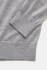 Nahaufnahme des Ärmelbündchens vom von Braun Merino Feinstrickpolo hellgrau, Slim Fit mit weichem Griff, feinem Strickbild, Skipper-Kragen und flexiblen Rippbündchen aus reiner Merinowolle, fotografiert von oben.