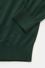 Nahaufnahme des von Braun Merino Feinstrickpolo dunkelgrün, gesehen von oben auf Ärmelbündchen aus feiner Merinowolle mit Skipper-Kragen, Slim Fit, weichem Griff und flexiblem Rippbündchen.