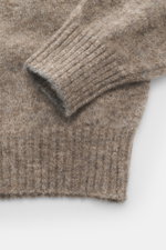 Nahaufnahme von Rippbündchen und Strickstruktur des taupe melierten Brunello Cucinelli Strickpolo, fotografiert von oben, aus Alpaka, Microfaser und Cashmere, Regular Fit, gestrickter Polokragen, Zwei-Knopf-Leiste, soft und hochwertig.