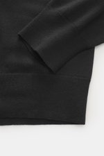 The Row Strickpolo 'Miranne' schwarz, Detailaufnahme der Ärmelbündchen und Saum, feines Strickbild, weicher Griff aus Kaschmir-Baumwoll-Mix.