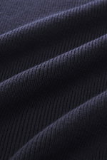 Ami Paris Merino Troyer navy/rot, Detailaufnahme der reinen Merinowolle mit weichem Griff aus schräger Perspektive, Regular Fit, Troyer-Kragen mit Zipper, Logo-Patch am Ärmel, farblich abgesetzte Ärmelabschlüsse.