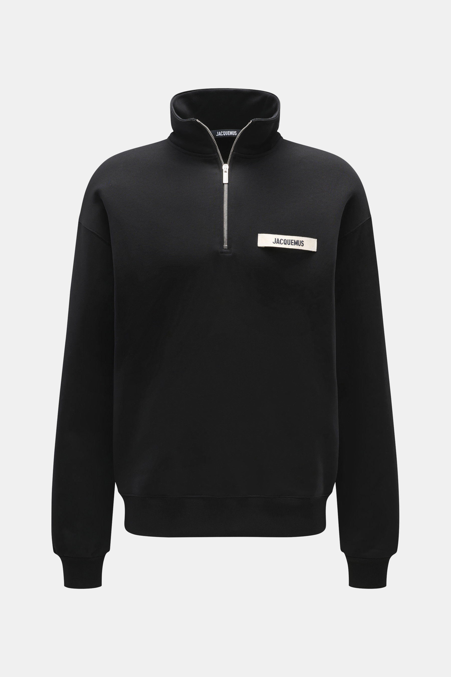 Frontale Nahaufnahme des Jacquemus Troyer 'Gros Grain' schwarz, Sweat aus reiner Baumwolle, schwere Qualität, softe Innenseite, Regular Fit, Troyer-Kragen mit Zipper, Grosgrain mit Logo-Stitching auf der Brust, komfortable Rippbündchen.