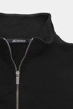 Close-up front view of Jacquemus Half-zip jumper 'Gros Grain' black, sweatshirt made of pure cotton, heavy quality, soft inner side, regular fit, stand-up collar with zipper, Grosgrain with logo stitching on chest, comfortable ribbed cuffs.