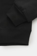 Close-up from above of the sleeve and hem of the Jacquemus Half-zip jumper 'Gros Grain' black, sweatshirt made of pure cotton, heavy quality, soft inner side, regular fit, stand-up collar with zipper, Grosgrain with logo stitching on the chest, comfortabl
