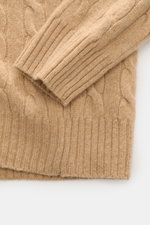 Nahaufnahme des Polo Ralph Lauren Troyer camel, fotografiert von oben, zeigt mittelfeinen Zopfstrick aus Wolle und Cashmere mit weichem Griff und Rippbündchen.