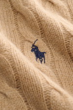 Nahaufnahme eines Polo Ralph Lauren Troyer camel aus Zopfstrick Wolle mit Cashmere, tonales Polospieler-Stitching, weicher Griff, mittelfeines Strickbild.