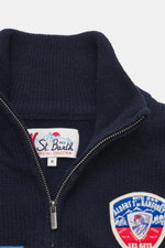 Close-up front view of the MC2 Saint Barth Quarter-zip jumper 'Buck' navy, featuring pure wool, soft feel, medium coarse knit pattern, patches with ski motifs, regular fit, stand up collar with zipper, and comfortable ribbed cuffs.