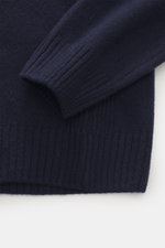 Nahaufnahme eines Ärmels und Bunds des 04651/ A trip in a bag Strickpolo navy, feines Strickbild, weicher Griff, Rippbündchen, Merinowolle und Cashmere.