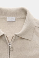 Nahaufnahme des 04651/ A trip in a bag Strickpolo sand aus Merinowolle und Cashmere, Slim Fit, feines Strickbild, Polokragen mit Zipper, von oben fotografiert.