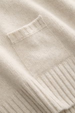 Detailaufnahme von seitlichen Rippstrick-Details und kleiner Tasche am 04651/ A trip in a bag Strickpolo sand aus Merinowolle und Cashmere.
