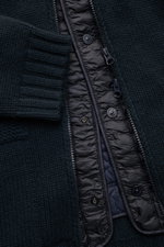 Nahaufnahme der Stone Island Cashmere Strickjacke 'Ghost Piece' navy aus der Ghost-Kollektion, perspektivisch von vorne fotografiert, zeigt das mittelgrobe Strickbild, flexible Rippbündchen, den Zwei-Wege-Reißverschluss und das herausnehmbare, windabweise
