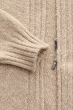 Nahaufnahme der Fioroni Cashmere Strickjacke sand meliert von oben mit Fokus auf den Zwei-Wege-Reißverschluss, schlankem Slim Fit, schrägen Hüfttaschen, mittelfeinem Strickbild, leichtem Bouclé-Effekt, flexiblem Rippbündchen und sehr weichem Griff aus rei