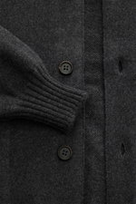 Close-up from above of the Fioroni Cashmere Cardigan dunkelgrau meliert showing its soft, fine knit with leather-reinforced button placket and ribbed cuff.

Description: Luxuriöser Cashmere für kalte Tage: Mit seinem besonders angenehmen, wärmenden Materi