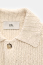 Nahaufnahme des Ami Paris Cardigan creme von oben, schwerer grober Rippstrick aus Alpaka, Wolle, Baumwolle mit Umlegekragen und Knopf.