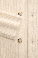 Nahaufnahme des Ami Paris Cardigan creme aus grobem Rippstrick mit Umlegekragen, Fünf-Knopf-Leiste und voluminöser Struktur.
