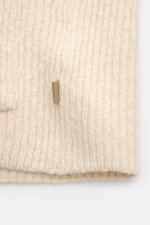 Nahaufnahme des cremefarbenen Ami Paris Cardigan mit grobem Rippstrick und sichtbarer aufgesetzter Hüfttasche, leichte griffige Haptik.