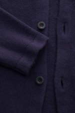 Nahaufnahme des 04651/ A trip in a bag Cardigan 'Knit Overjacket' navy aus mittelfeinem Strick mit Schalkragen, glatter Knopfleiste und Fronttaschen, fotografiert von oben. Quiet Luxury: Mix aus Wolle und Cashmere, weicher Griff, Regular Fit.