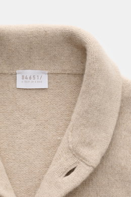 Nahaufnahme von Schalkragen und Label des 04651/ A trip in a bag Cardigan 'Knit Overjacket' beige meliert aus weichem Woll-Cashmere mit mittelfeinem Strick.