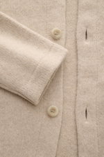 Nahaufnahme des 04651/ A trip in a bag Cardigan 'Knit Overjacket' beige meliert mit mittelfeinem Strick, Schalkragen, glatter Knopfleiste und Fronttaschen, weicher Wolle-Cashmere-Mix, Regular Fit, aus frontaler Perspektive fotografiert.