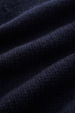 Nahaufnahme des grob gestrickten Stoffes in Navy des 04651/ A trip in a bag Cardigan 'Bold' aus reiner, weicher Lammwolle.