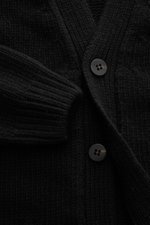 04651/ A trip in a bag Cardigan 'Bold' schwarz in Nahaufnahme von vorne, grober Strick, reine Lammwolle, weicher Griff, Oversized Fit, Vier-Knopf-Leiste, aufgesetzte Fronttaschen.