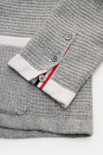 Nahaufnahme des Thom Browne Cardigans hellgrau meliert, Detailansicht des Ärmels mit Tricolore-Ripsband, vier Knöpfen, markantem Strickmuster aus Leinen, Baumwolle und Microfaser.